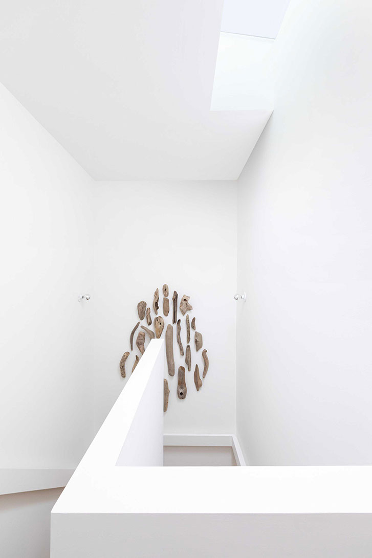 The stairway with a collection of driftwood hung upon the wall
