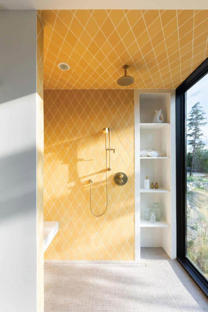 The yellow motif from the kitchen is echoed in the master bath, with diamond tiles in a stunning shade of sunshine. The shower has no door separating it from the rest of the ensuite (though it does feature a floor-to-ceiling window).