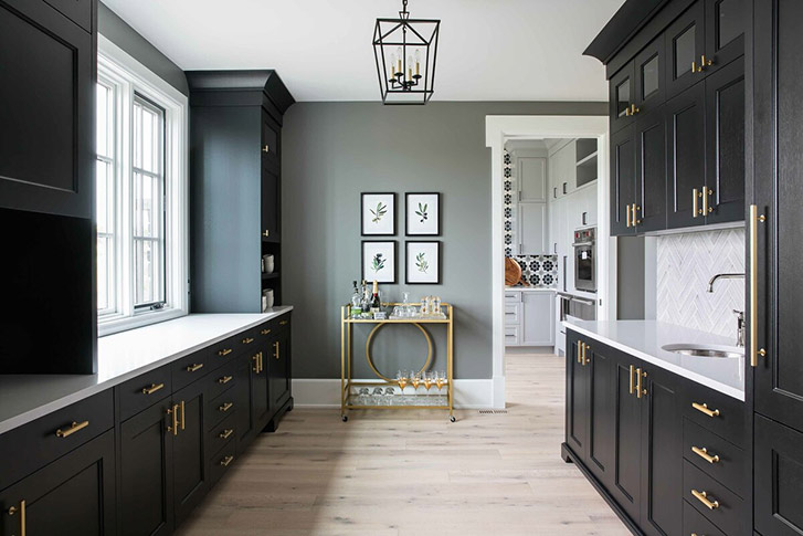 The butler's kitchen includes black cabinetry and a gold bar cart