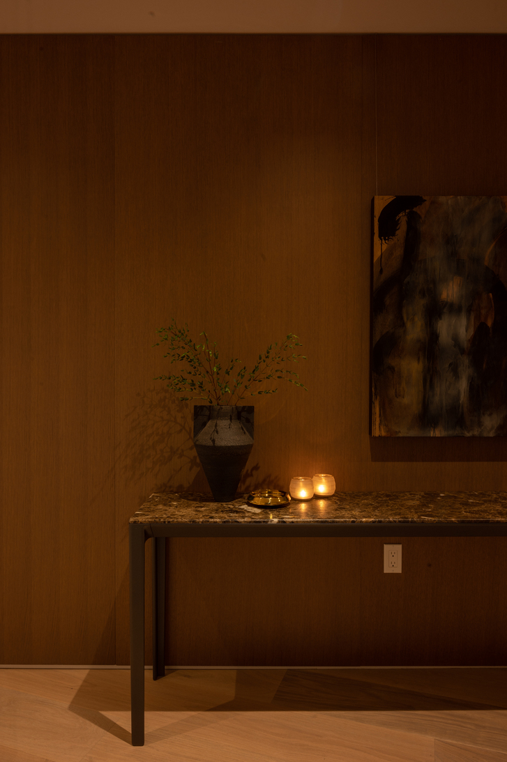 Dimly lit room with a candle and wood wall.