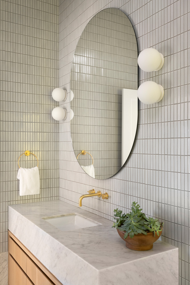 japanese inspired bathroom with a round mirror and lights
