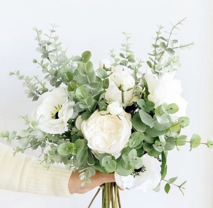 a bouquet of fake white flowers and greenery