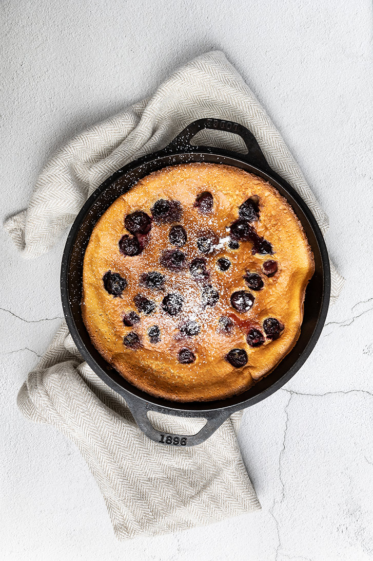 A fresh cherry clafoutis with flour on top ready to be served
