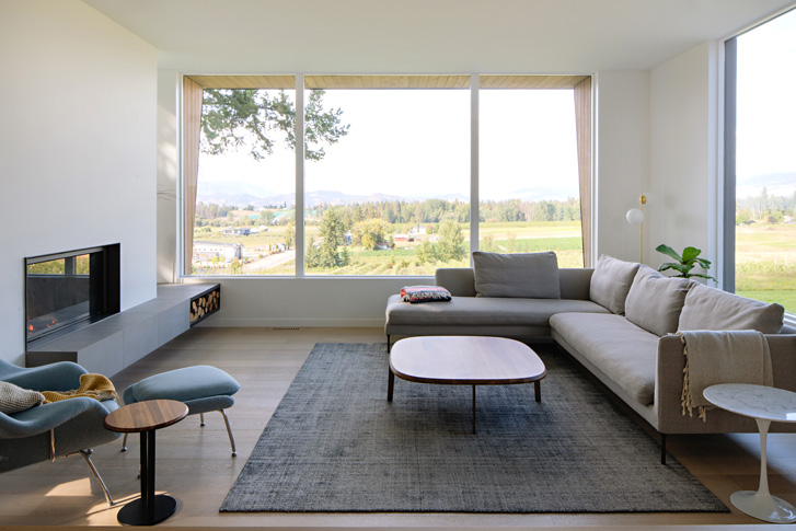 A living room that cantilevers out over and apple orchard.