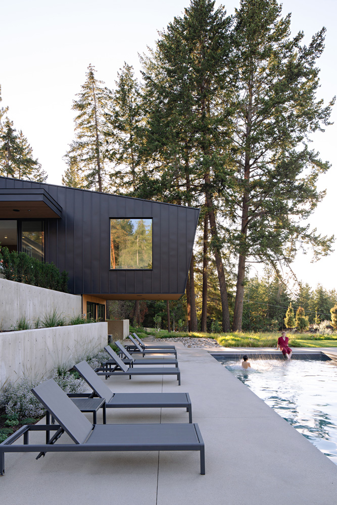 A cantilevered home clad in black metal.