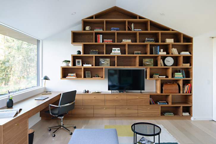 A home office with shelving built-in to the gabled roof.
