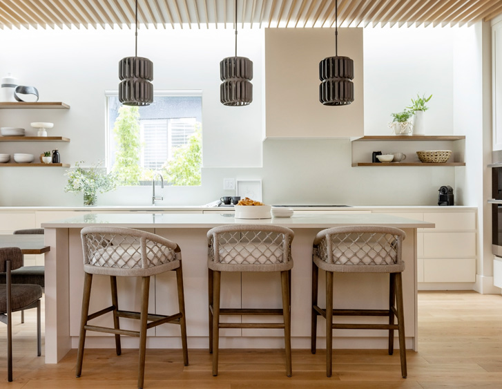 kitchen island with three stools and pendant lights