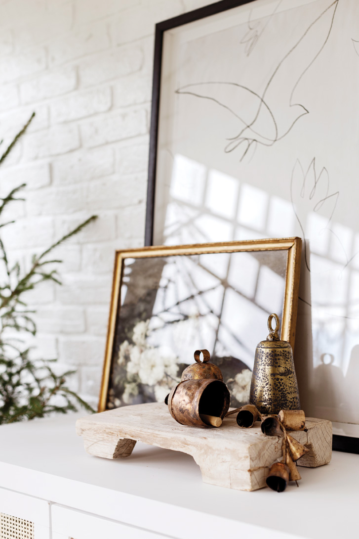 Vintage bells bring patina to the all-white space. Photo: Janis Nicolay