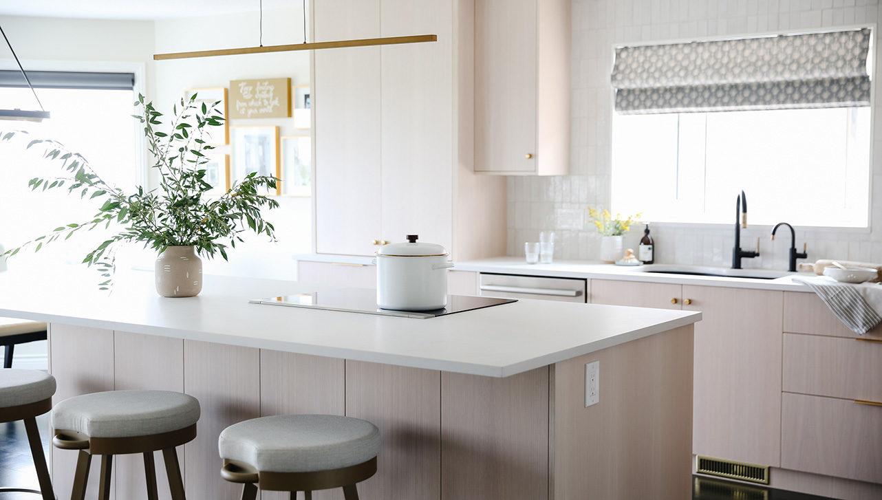 a kitchen with light coloured cabinets awash in natural light