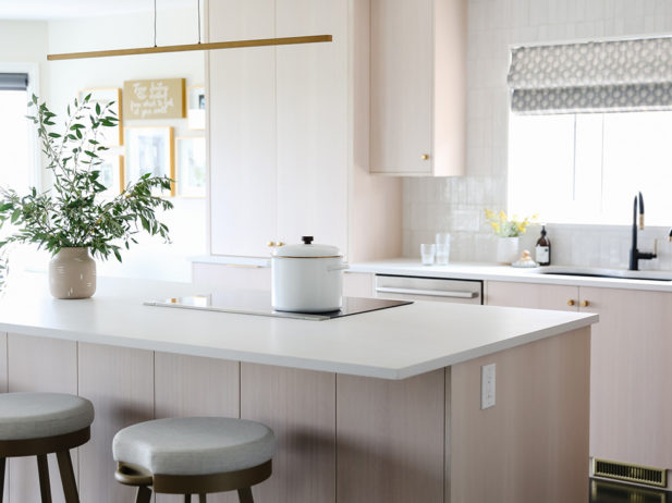 a kitchen with light coloured cabinets awash in natural light