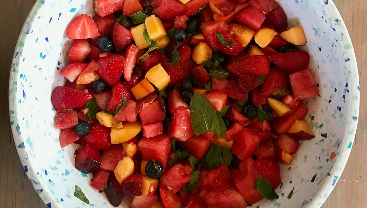colourful fruit salad with mint leaves and a delicious dressing