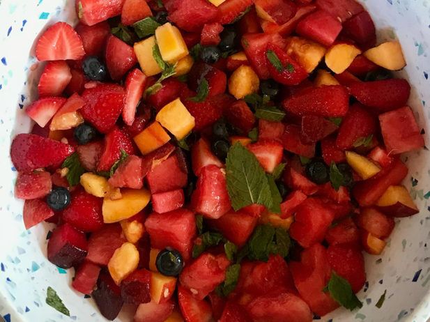 colourful fruit salad with mint leaves and a delicious dressing
