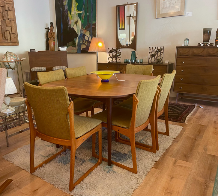 Wood Dining table with green fabric and wood chairs in shop