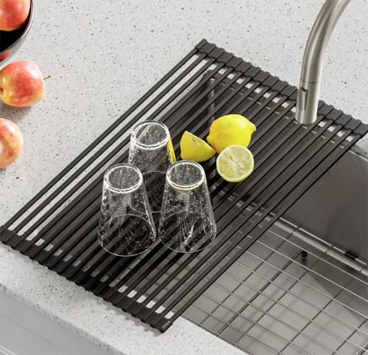 roll up dish rack is displayed in use atop a sink with dishes drying on it