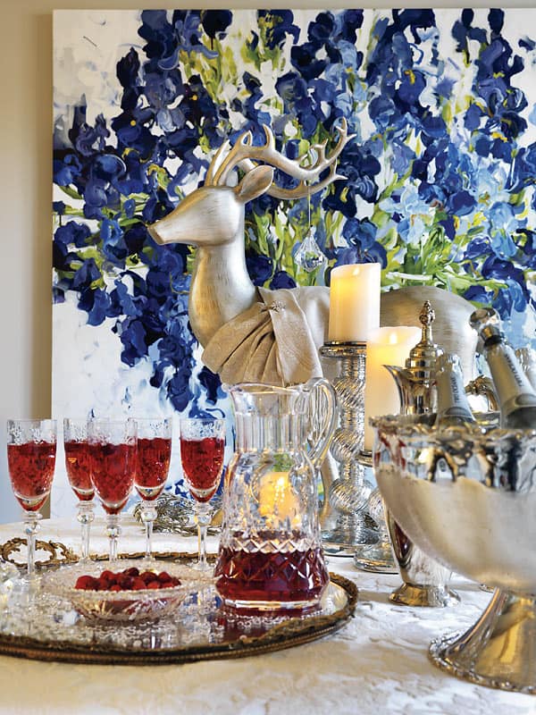 Make a seasonally themed cocktail With the white and silver backdrop, a pretty cranberry and champagne cocktail (top) pops as part of the decor (and your guests will love it).