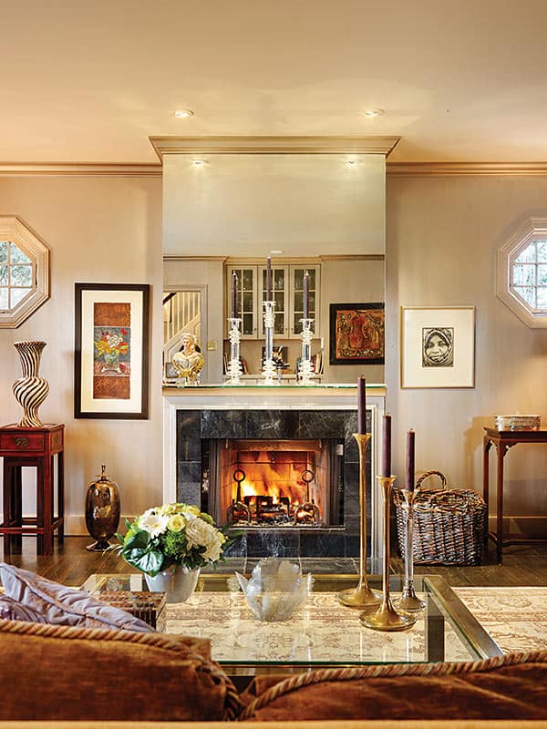 Warm Welcome | A glass mantel simplifies the lines around the fireplace; it’s topped with a bust that designer Coco Cran found for the couple. “Her presence is very much here,” says Peggy. 