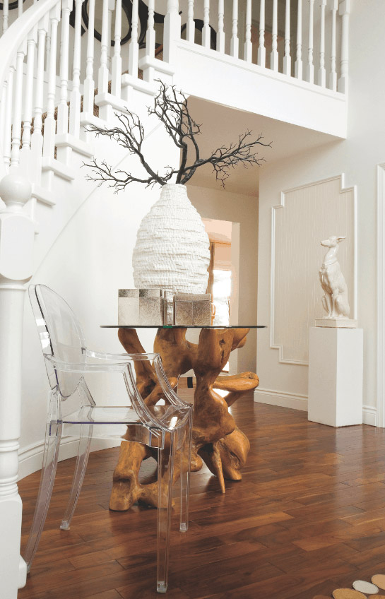ENTRANCE: A Jonathan Adler ceramic greyhound statue adds a touch of whimsy to the entrance, where a teak root table and 18Karat vase provide an elegant focal point.