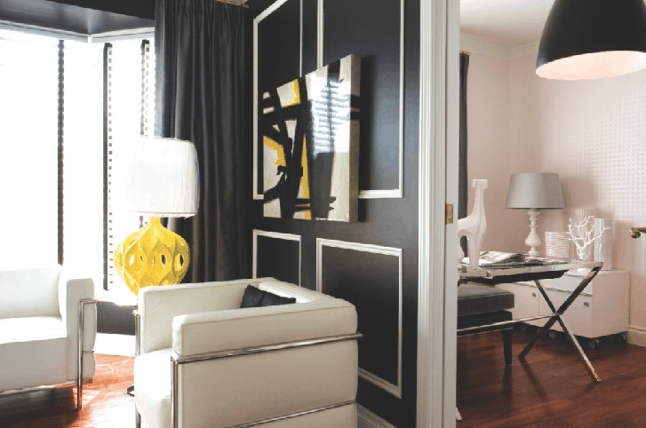 OFFICE: Bucking convention, Foord opted to paint the wall panels in reverse: Oxford white for the trim, rich black on the walls. The yellow lamp adds a surprising pop of colour in the graphic room. 
