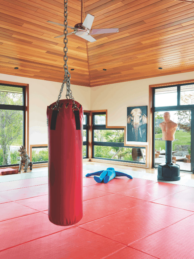 DOJO: A regulation-size judo mat is bordered by windows that frame garden views. 