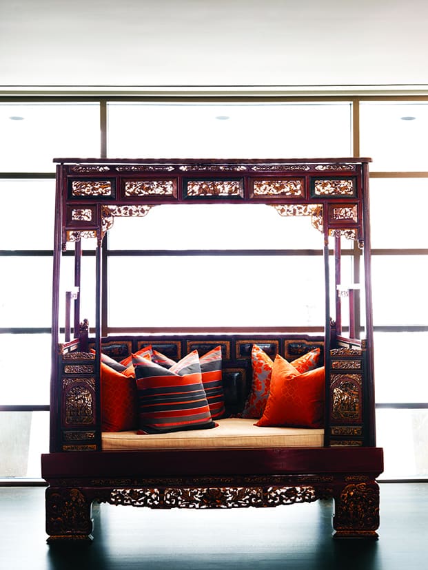 An antique Asian day bed with contemporary cushions.