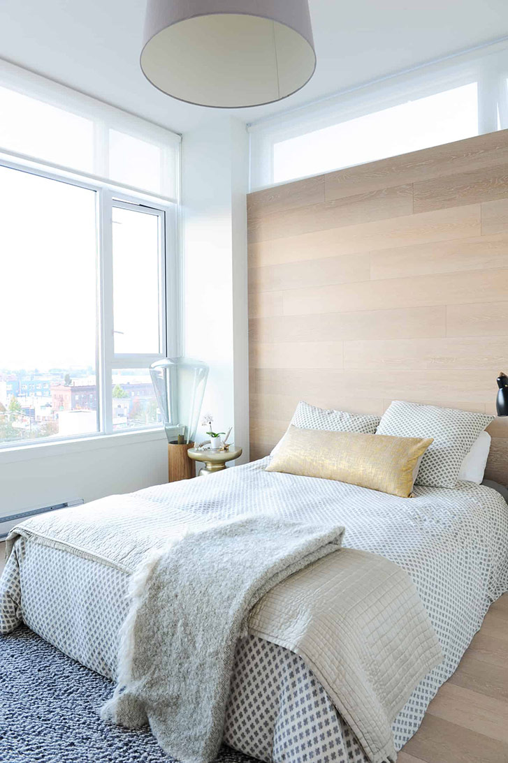 There’s no headboard in the master bedroom—rather, brushed oak floor planks create a unique feature wall behind a pile of cozy pillows from CB2 and West Elm.
