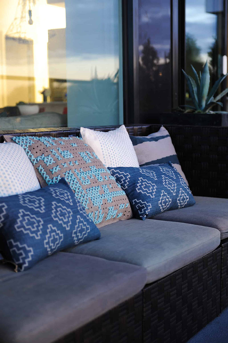The patio features a stunning aerial view of bustling Mount Pleasant, and a mix of high and low pieces: a wicker sofa from Canadian Tire is elevated by graphic throw cushions from Livingspace.