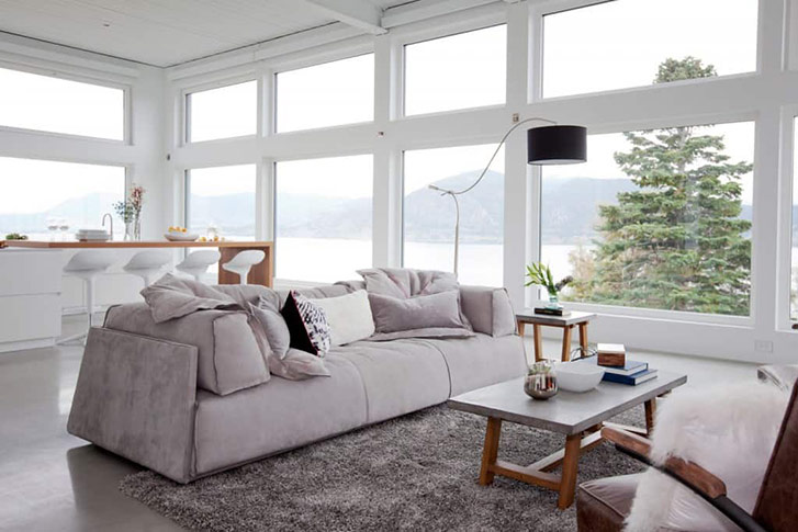 The neutral colour palette used in the main room of this Okanagan home doesn’t distract from the show outside the floor-to-ceiling windows. 
