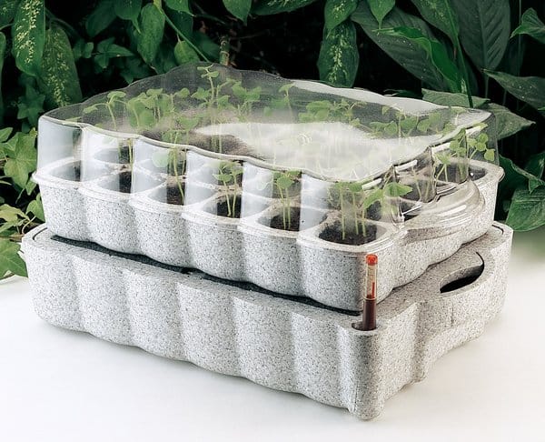 A seed-starting tray with a lower water-containing reservoir, a capillary mat that wicks water from the reservoir to the soil above, and a transparent cover to minimize evaporative water losses