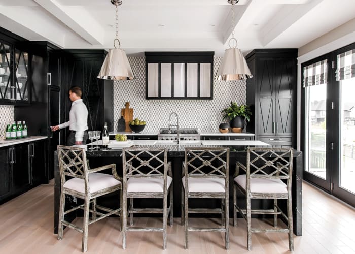 Black cabinets and countertops create balance amongst the distressed-oak bar stools and diamond backsplash in this dark and dramatic kitchen from Atmosphere Interior Design (Photo: Elaine Mark)