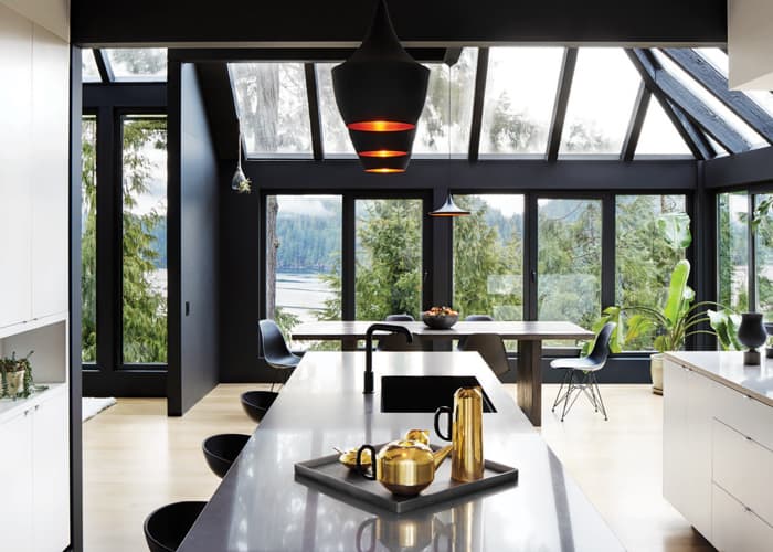 All-around windows in this D’Arcy Jones kitchen keep this kitchen—Black pendant lights: Check! Dark faucets: Check! Sleek bar stools and dining chairs: Check!—from being too dark (Photo: Martin Tessler)