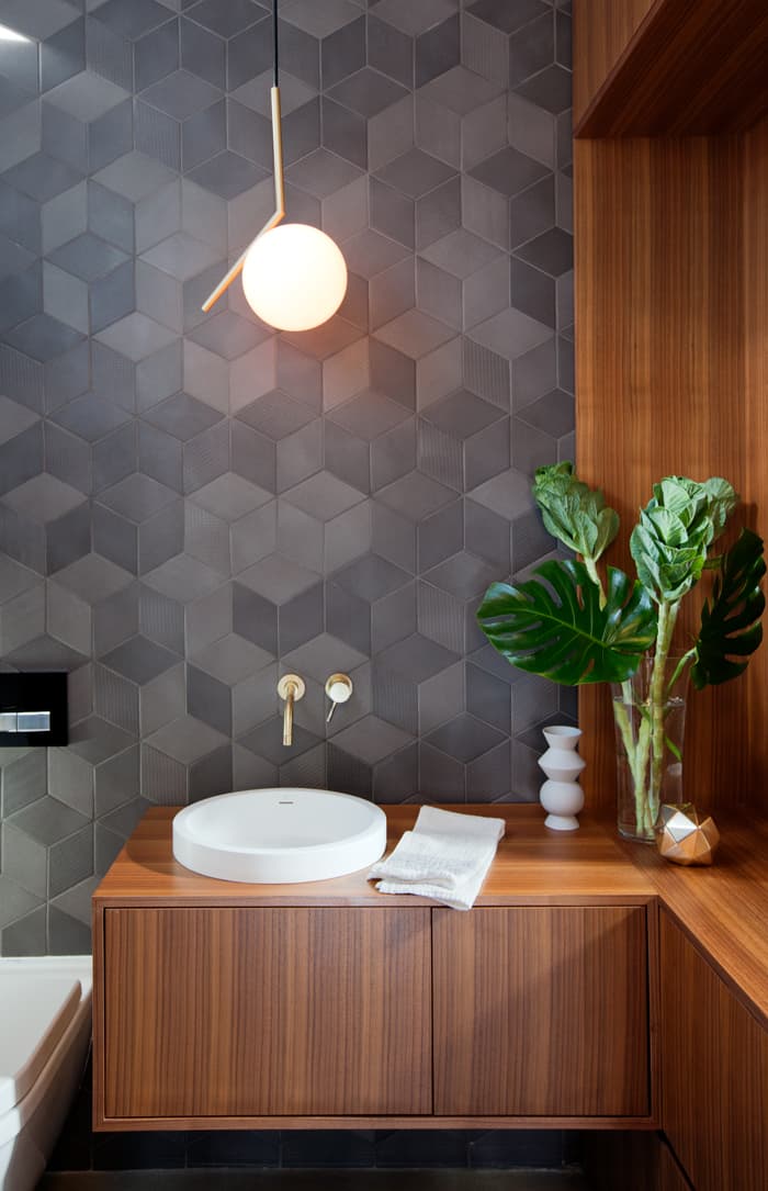 The angular Flos light in the powder room mirrors the angles in the “Textile” tile.