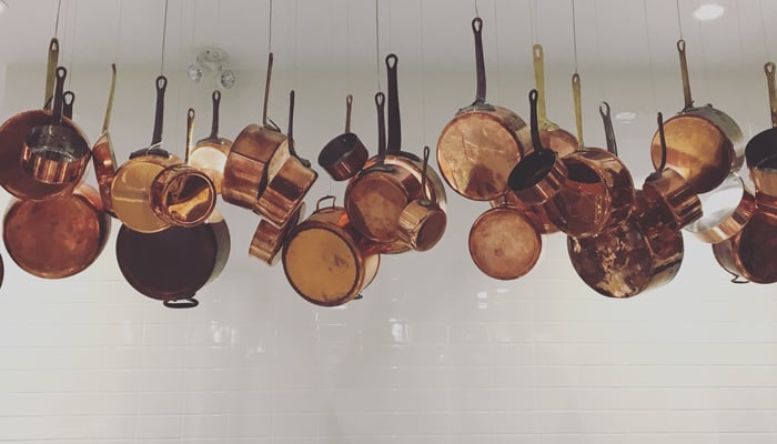 Copper pots are suspended above the kitchen, adding a touch of whimsy to the modern space. (The gorgeous light installation was designed by our 2016 Industrial Designer of the Year Matthew McCormick.)
