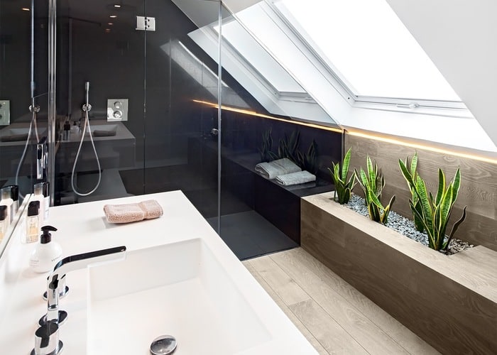 Wooden planter in black and white bathroom.
