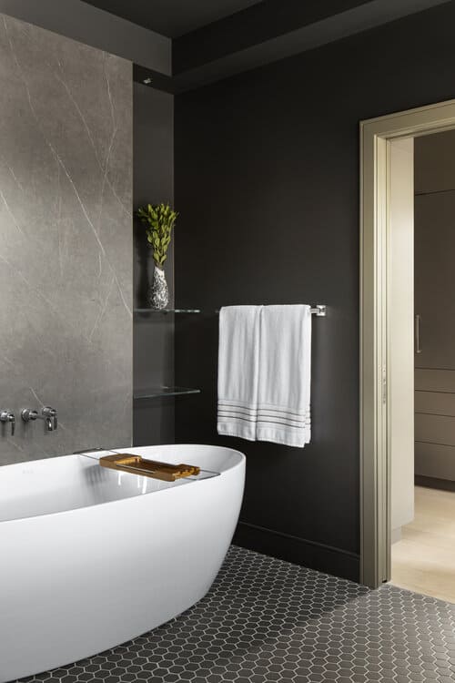 A Fluerco bathtub is inside the bedroom's ensuite, with decorative Porcelainosa ceramic tiles